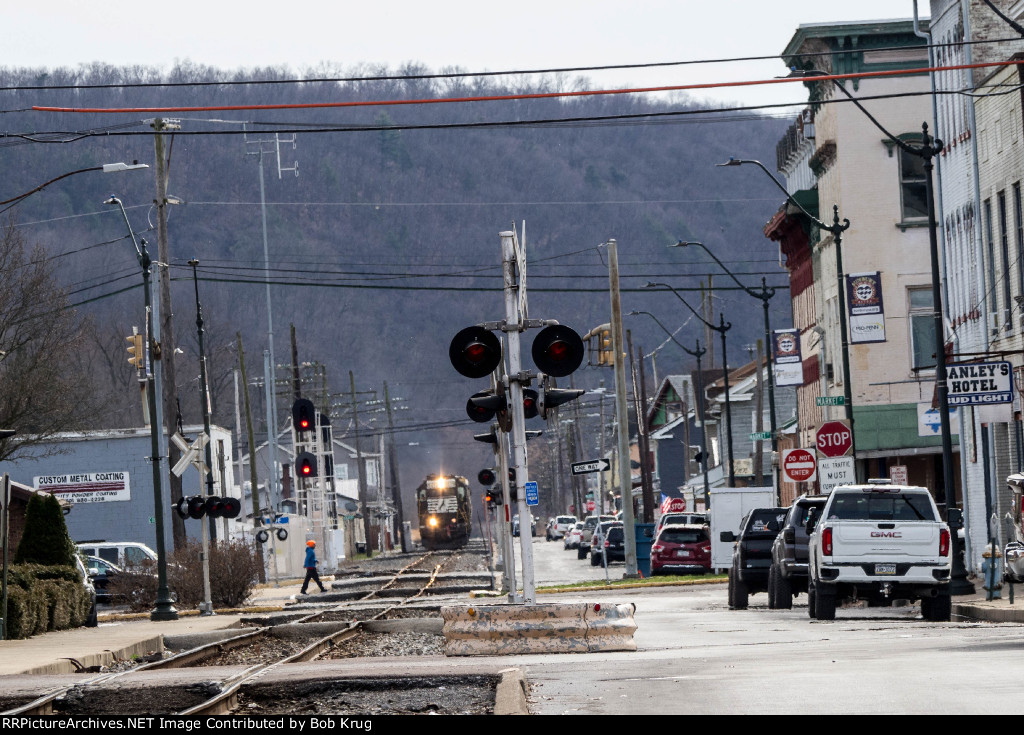 Telephoto view looking down third Street in Sunbury as a northbound freight train approaches